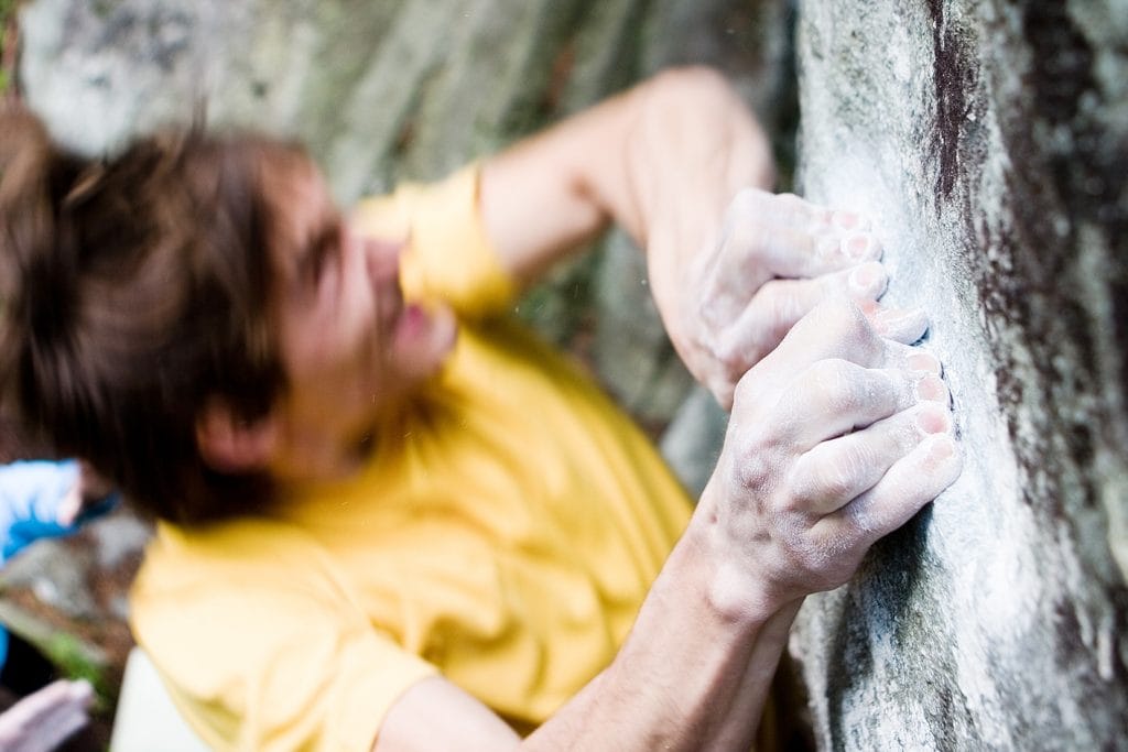 Kletterer crimpt beim Bouldern